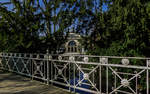 Im <u><a href= https://www.wiesbaden.de/leben-in-wiesbaden/freizeit/natur-erleben/gruenanlagen-parks/kurpark-wiesbaden.php  target= _blank >Wiesbadener Kurpark</a></u> führt diese Brücke mit einem hübschen Geländer auf eine kleine Halbinsel im Kurpark-Weiher, von wo aus man die Rückseite des Kurhauses zwischen den Bäumen hindurch erspähen kann. (25.03.2018)